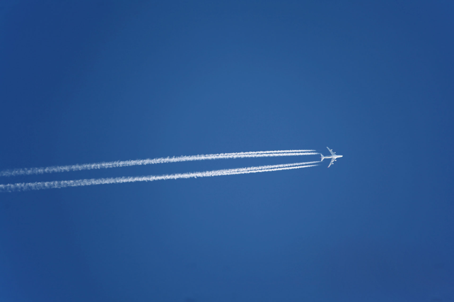 Jet steam from airplane travelling over clear blue sky